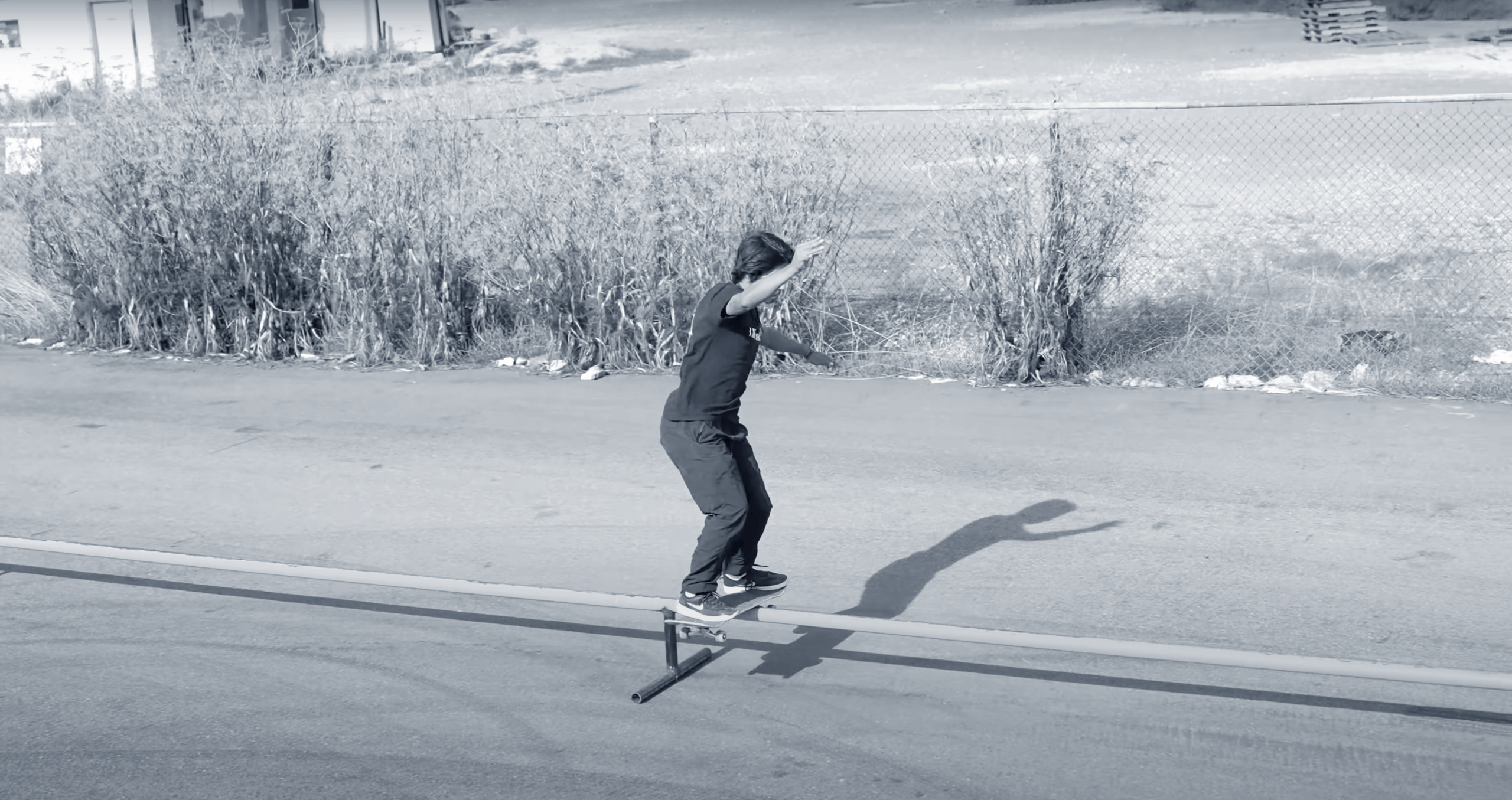 Skater grinding on long rail